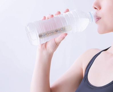 トリプル還元スティックの水で水分補給をする女性